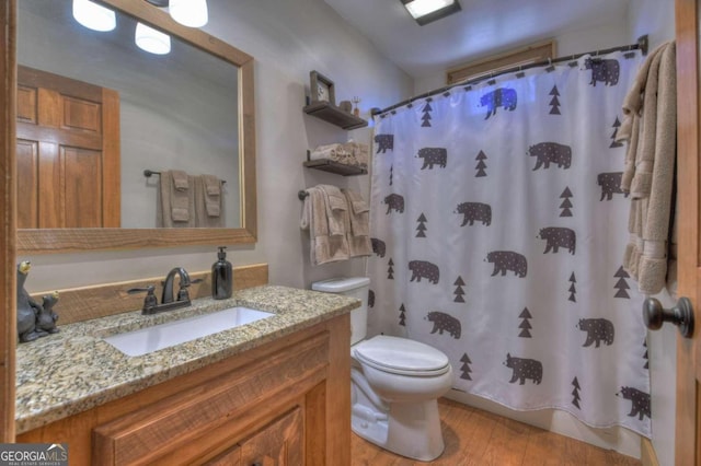 bathroom featuring a shower with shower curtain, vanity, toilet, and wood-type flooring