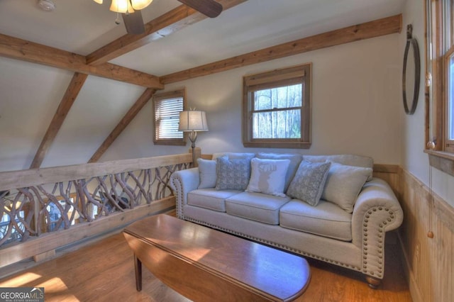 living room featuring vaulted ceiling with beams, ceiling fan, and wood-type flooring