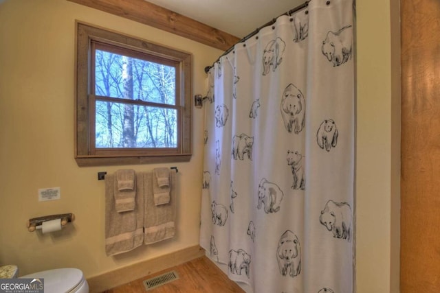 bathroom featuring a shower with curtain, wood-type flooring, and toilet