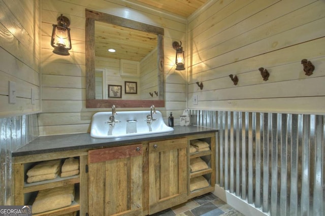 bathroom with vanity, wooden ceiling, and wood walls