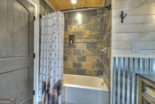 bathroom with shower / bath combo with shower curtain and wood walls