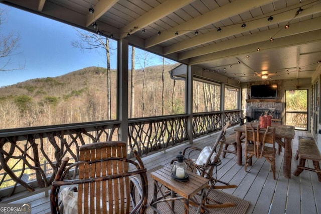 deck featuring a mountain view and a fireplace