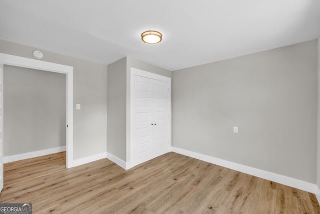 unfurnished bedroom featuring light hardwood / wood-style flooring and a closet