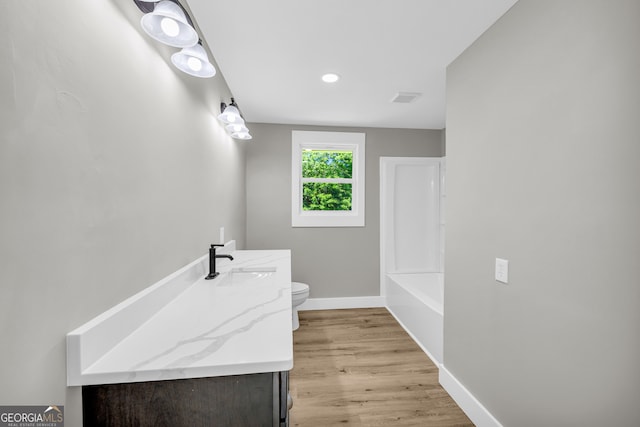 bathroom featuring vanity, wood-type flooring, and toilet