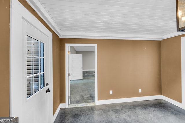 empty room featuring ornamental molding and concrete floors