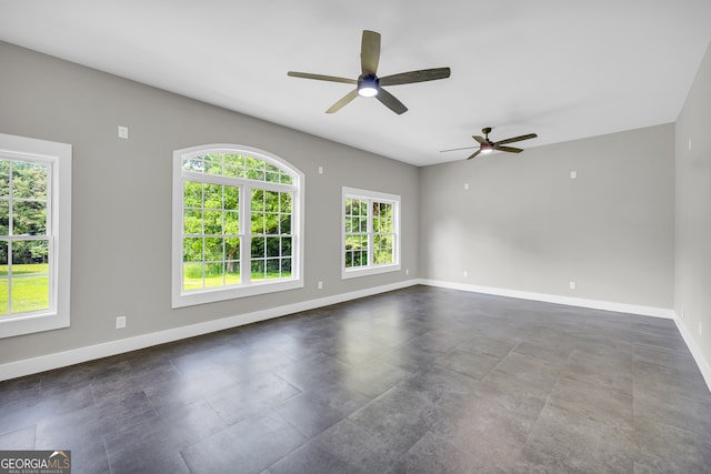 empty room with ceiling fan and a healthy amount of sunlight