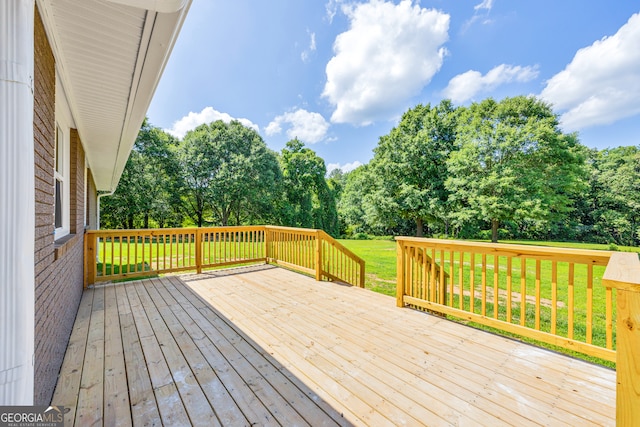 wooden terrace featuring a lawn