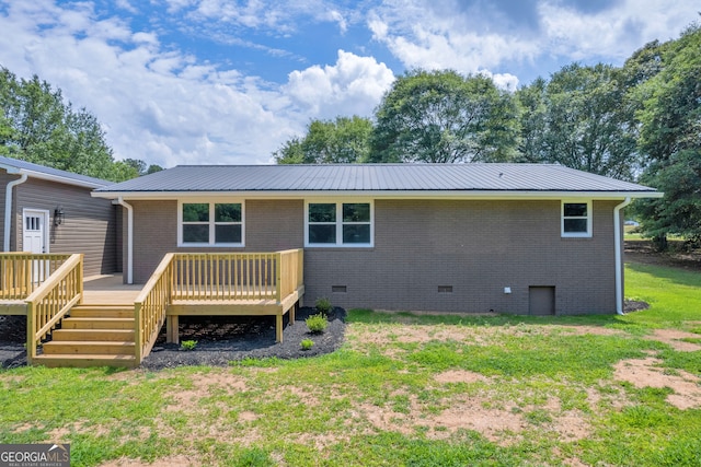 back of property featuring a wooden deck and a yard