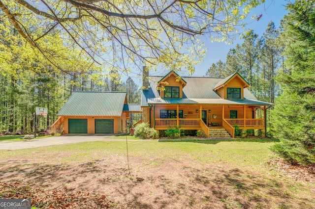 cabin featuring a front lawn, covered porch, and a garage