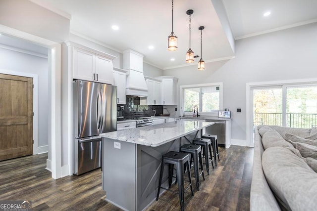 kitchen featuring dark hardwood / wood-style floors, a center island, white cabinetry, and stainless steel appliances