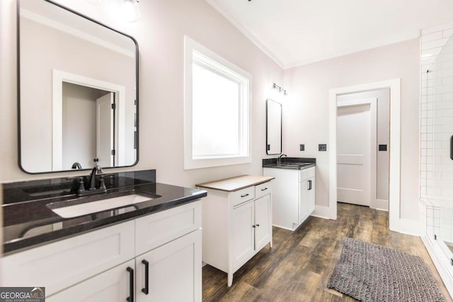 bathroom with hardwood / wood-style floors, vanity, tiled shower, and crown molding