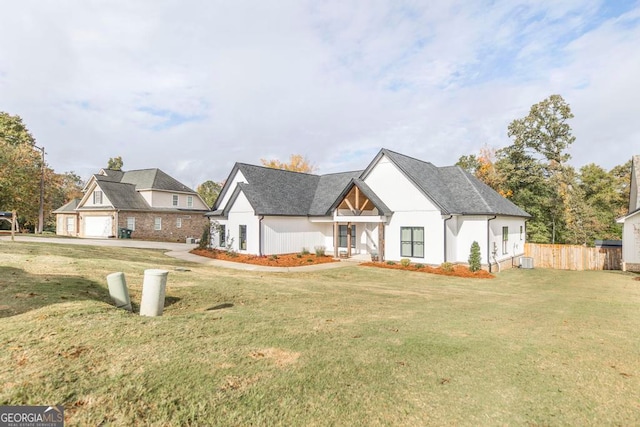 view of front of property with central AC, a garage, and a front lawn