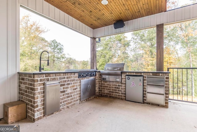 view of patio with sink, an outdoor kitchen, and a grill