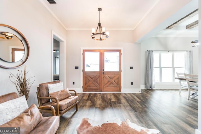 foyer with a chandelier, dark hardwood / wood-style flooring, plenty of natural light, and crown molding