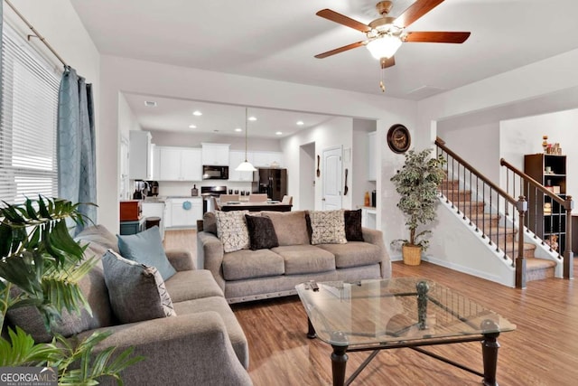 living room featuring ceiling fan and light hardwood / wood-style floors