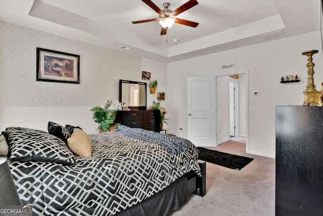 bedroom featuring a tray ceiling, ceiling fan, and carpet floors