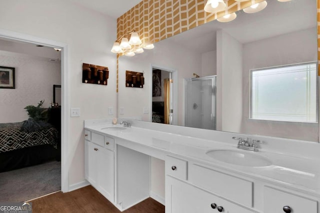 bathroom with wood-type flooring, vanity, and a shower with door