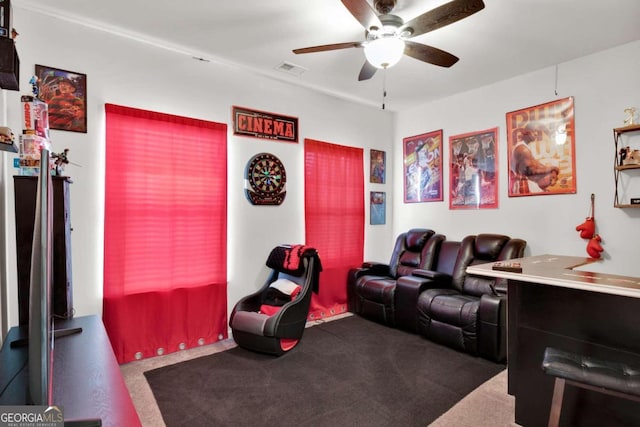 home theater featuring ceiling fan and dark colored carpet