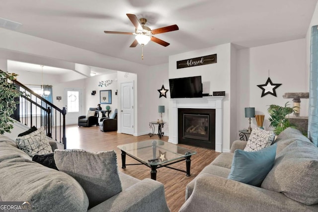 living room with light hardwood / wood-style flooring and ceiling fan