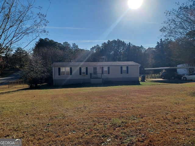 manufactured / mobile home with a carport and a front lawn