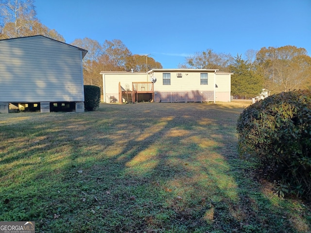 back of property with a yard and a deck