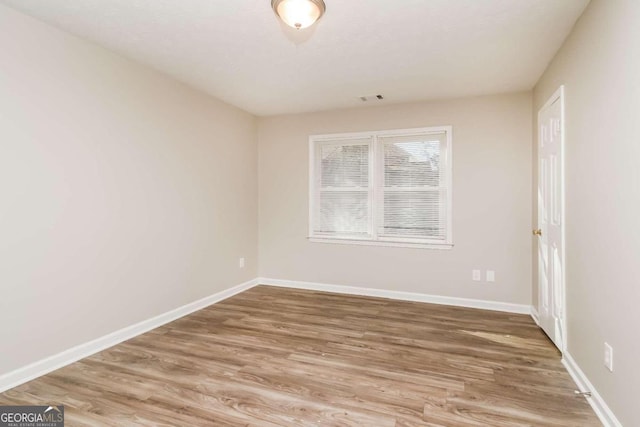 spare room with hardwood / wood-style flooring