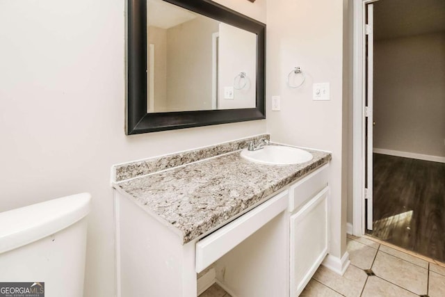 bathroom featuring tile patterned floors, vanity, and toilet