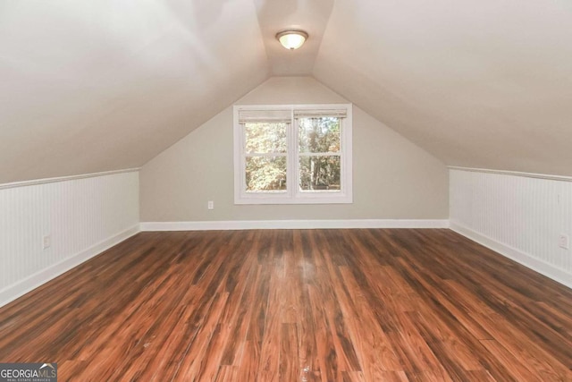 bonus room with dark hardwood / wood-style flooring and vaulted ceiling