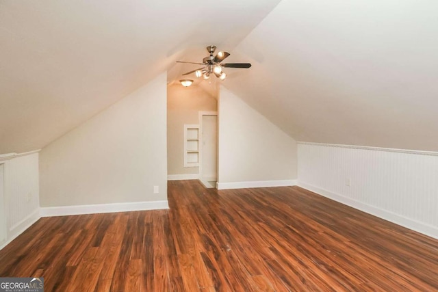 additional living space featuring ceiling fan, dark wood-type flooring, and vaulted ceiling