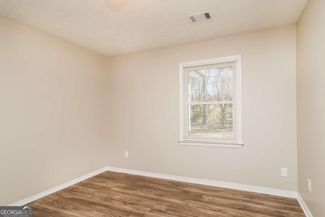 empty room featuring hardwood / wood-style floors and a textured ceiling