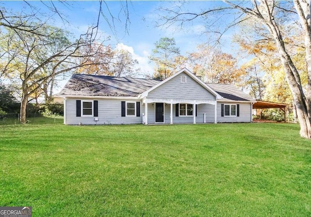 view of front of property featuring a front yard and a carport