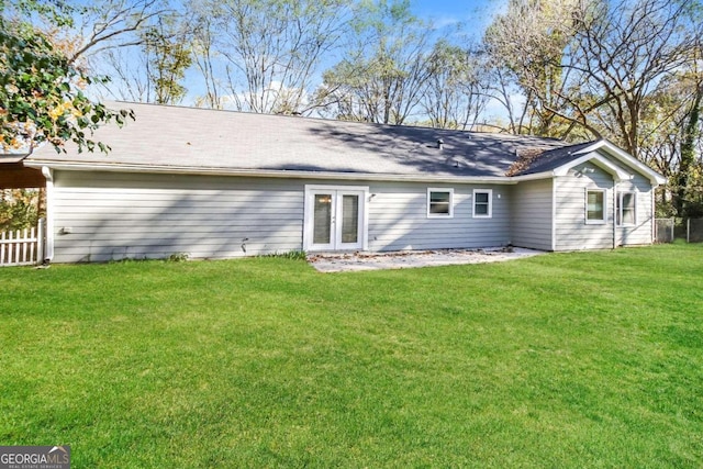 back of house with french doors and a lawn