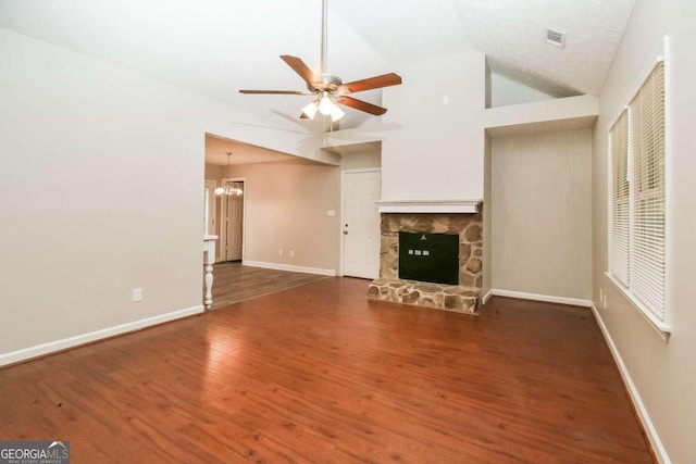 unfurnished living room featuring a fireplace, ceiling fan with notable chandelier, dark wood-type flooring, and vaulted ceiling