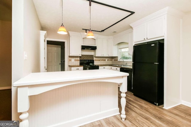 kitchen featuring tasteful backsplash, pendant lighting, light hardwood / wood-style floors, white cabinets, and black appliances