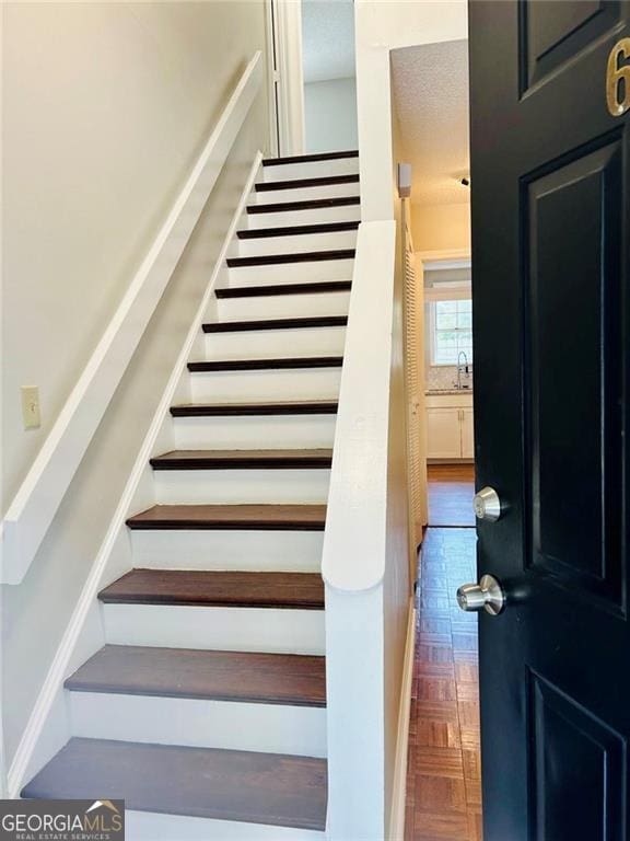 staircase featuring parquet floors and sink