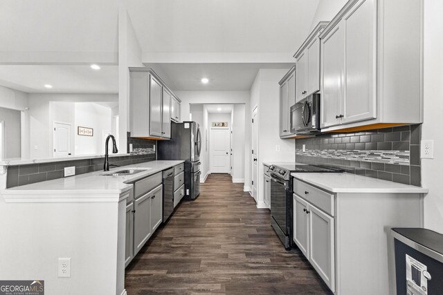 kitchen featuring sink, stainless steel appliances, dark hardwood / wood-style flooring, backsplash, and gray cabinets