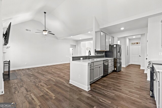 kitchen featuring dark wood-type flooring, sink, vaulted ceiling, kitchen peninsula, and stainless steel appliances