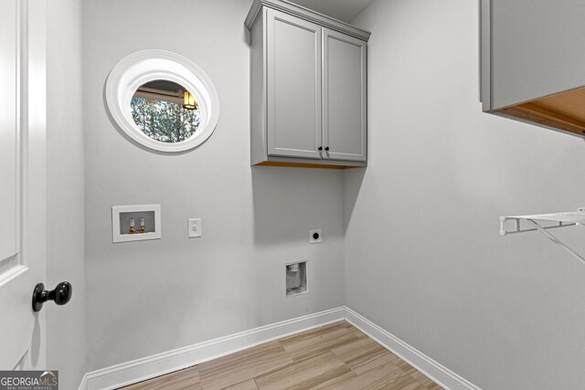 laundry area featuring hookup for an electric dryer, hookup for a washing machine, light hardwood / wood-style floors, and cabinets