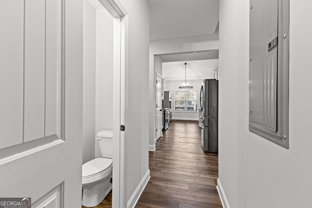 hall with dark hardwood / wood-style floors and a notable chandelier