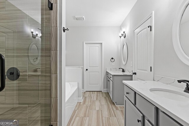 bathroom featuring vanity and shower with separate bathtub