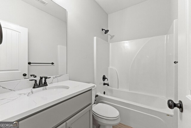 full bathroom with bathtub / shower combination, vanity, and toilet