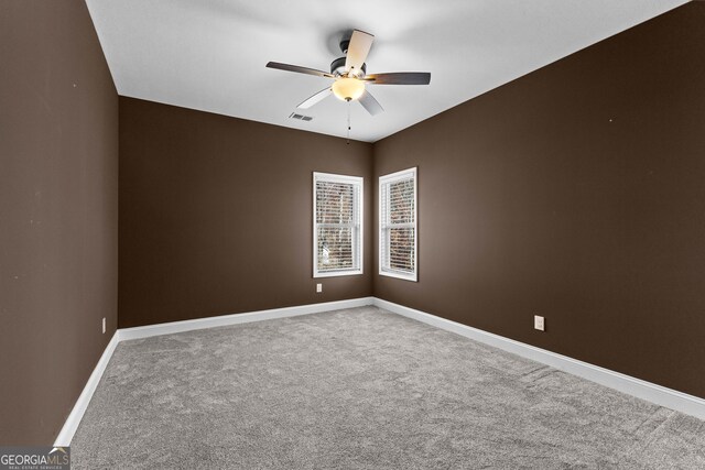 carpeted spare room with ceiling fan