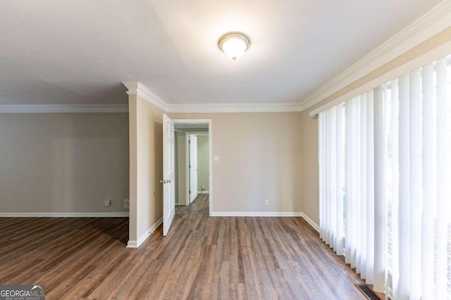 spare room featuring crown molding and dark wood-type flooring