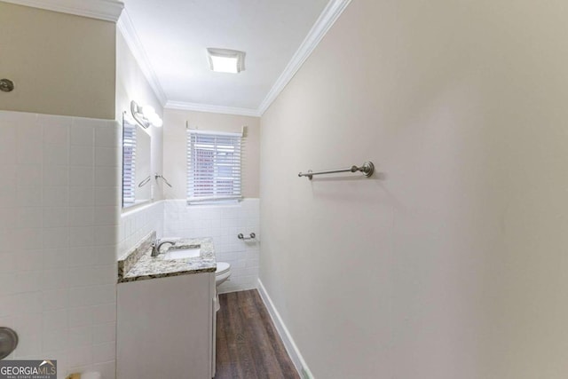 bathroom featuring crown molding, hardwood / wood-style floors, toilet, vanity, and tile walls