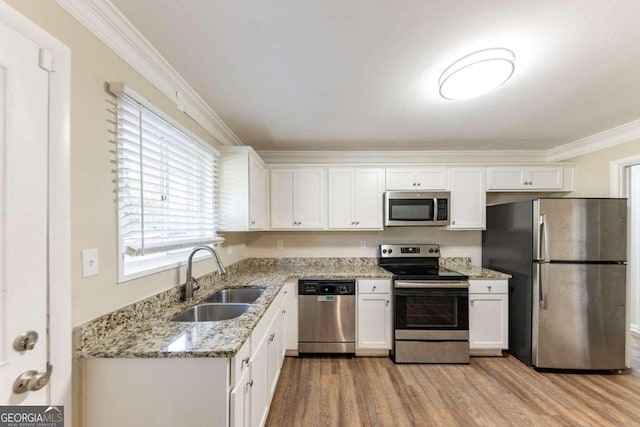 kitchen with appliances with stainless steel finishes, white cabinetry, crown molding, and sink