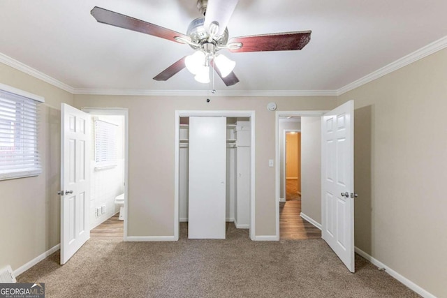 unfurnished bedroom with ceiling fan, light colored carpet, ensuite bathroom, and crown molding