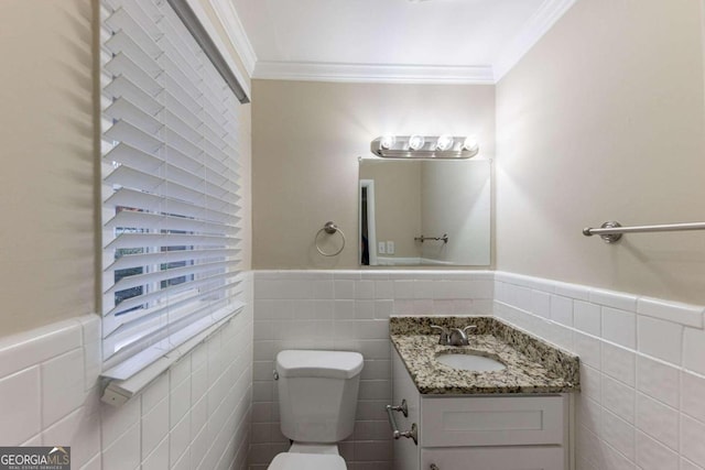 bathroom with toilet, vanity, tile walls, and ornamental molding