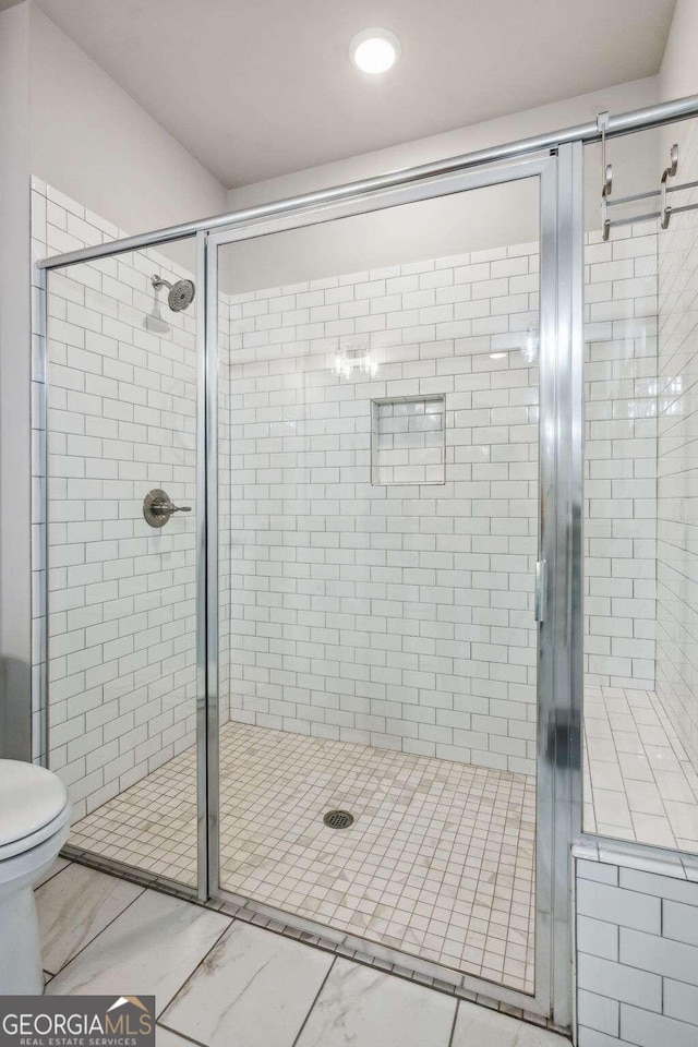 bathroom with toilet and an enclosed shower