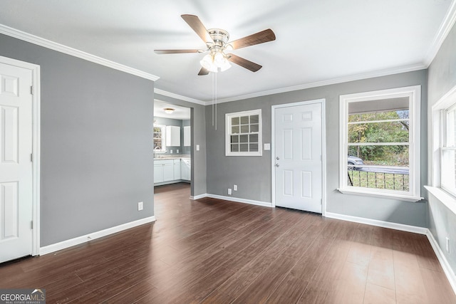 interior space featuring dark wood-style floors, baseboards, crown molding, and ceiling fan