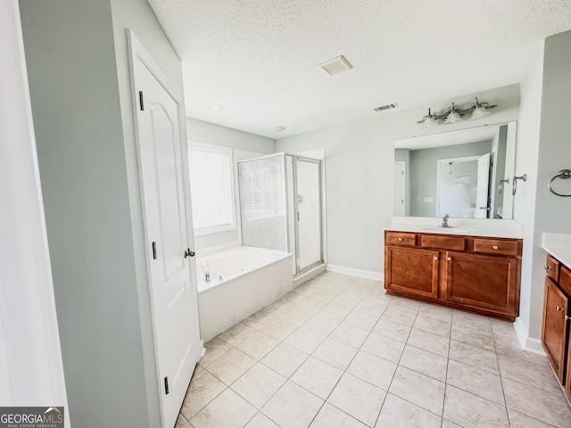 bathroom featuring separate shower and tub, tile patterned floors, vanity, and a textured ceiling